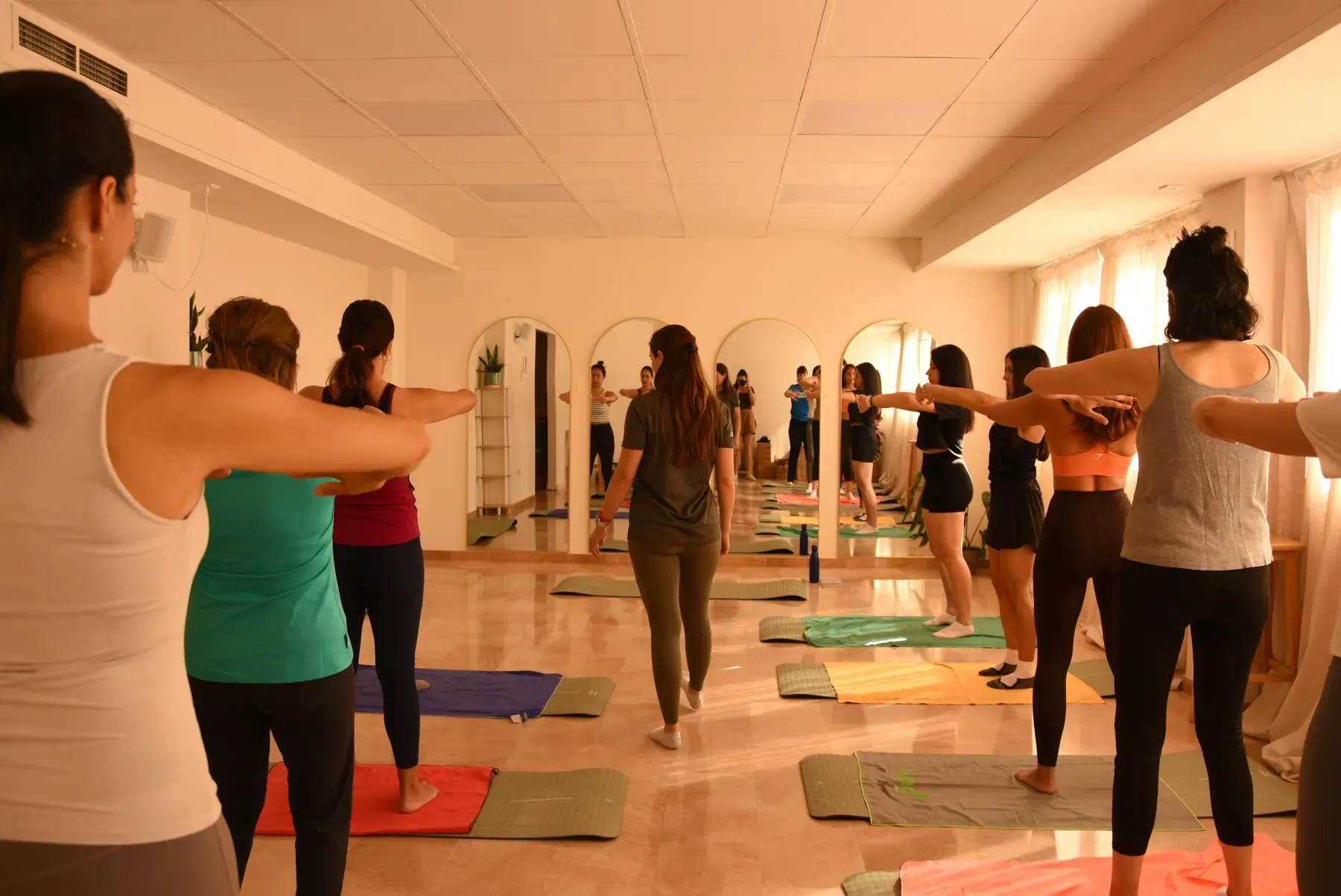Clase de movimiento en grupo sobre esterillas en una sala luminosa